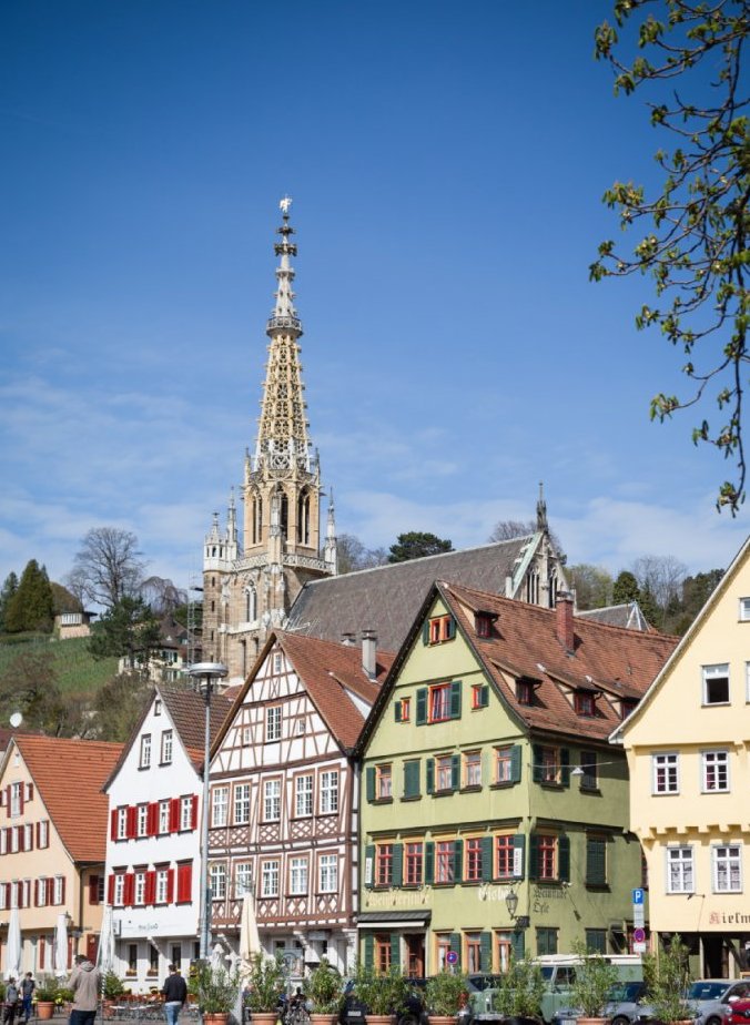 Front einer Häuserreihe in Esslingen mit Kirchturm im Hintergrund